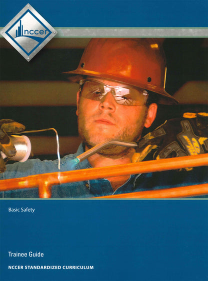 Worker wearing safety gear welding copper pipe on cover of Basic Safety Trainee Guide by NCCER