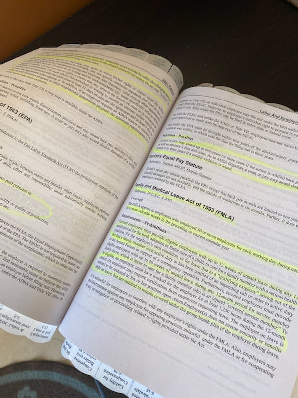 Open book pages with highlighted text and multiple tabs marking sections for quick reference and study aid