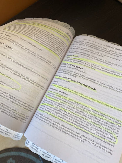 Open book pages with highlighted text and multiple tabs marking sections for quick reference and study aid